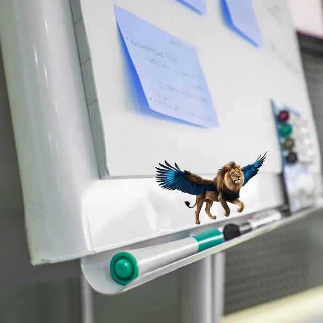 Flipchart mit blauen Haftnotizen, darauf ein kleiner geflügelter Löwe